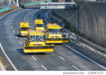 A convoy of snowplows traveling on a highway in winter / Road maintenance work in progress V1 138041575