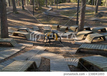 Vivid Bee Figure On Forest Pathway Scene. Bright Yellow Sculpture Of Bee Placed In Nature Environment Vivid Bee Figure On Forest Pathway Scene. Bright Yellow Sculpture Of Bee Placed In Nature Environment 138041893