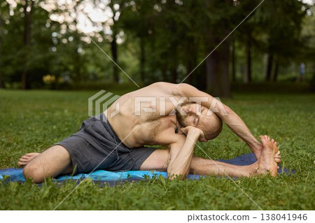 An individual outdoors performing smooth and peaceful stretching exercises 138041946