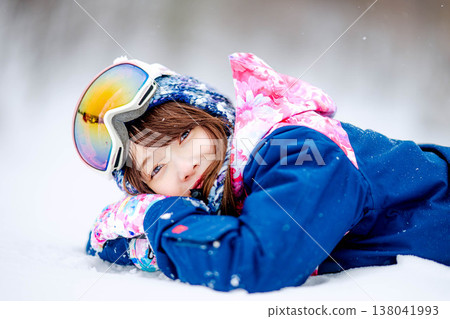 一位年輕女子躺在雪地上 138041993