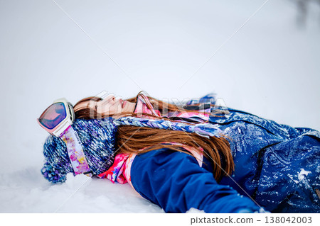 A young woman lying on the snow A young woman lying on the snow 138042003