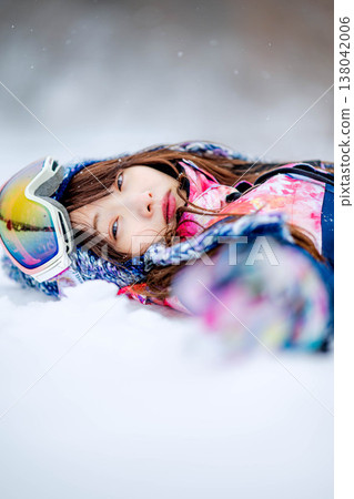 A young woman lying on the snow 138042006