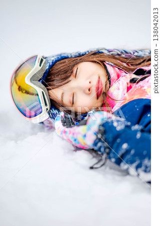 一位年輕女子躺在雪地上 138042013