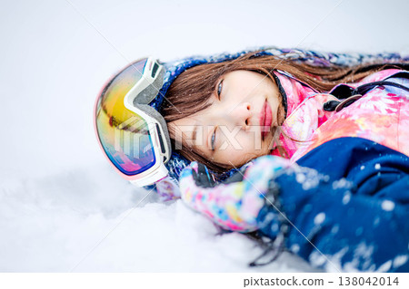一位年輕女子躺在雪地上 138042014