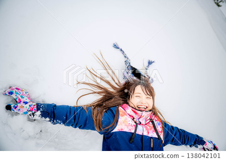 一位年輕女子躺在雪地上 138042101