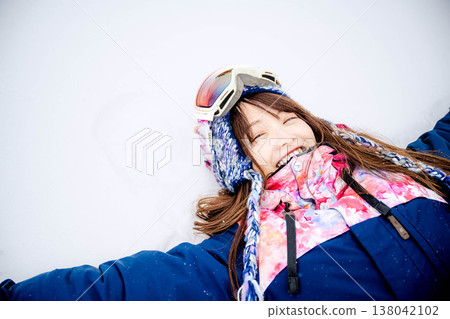 一位年輕女子躺在雪地上 138042102