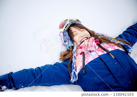 一位年輕女子躺在雪地上 138042103
