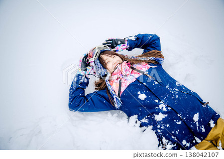 一位年輕女子躺在雪地上 138042107