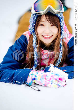 一位年輕女子躺在雪地上 138042109