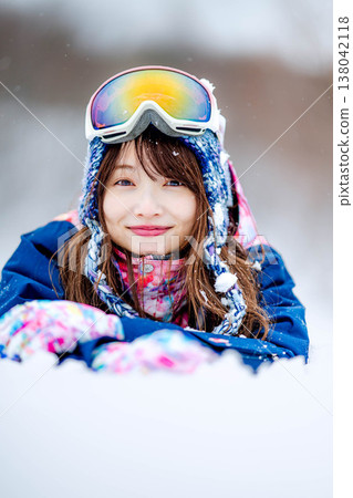 A young woman lying on the snow 138042118