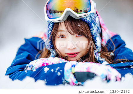 一位年輕女子躺在雪地上 138042122