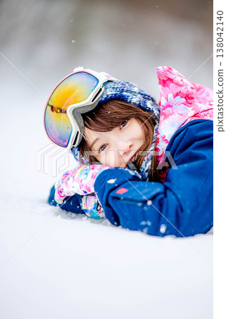 A young woman lying on the snow A young woman lying on the snow 138042140