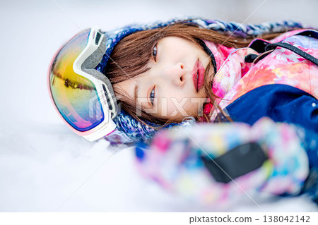 A young woman lying on the snow A young woman lying on the snow 138042142