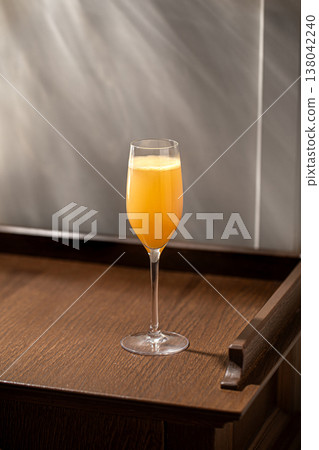 Orange cocktail in champagne glass on wooden table 138042240
