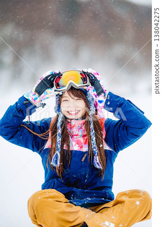 A young woman in ski wear sitting on the snow. 138042275