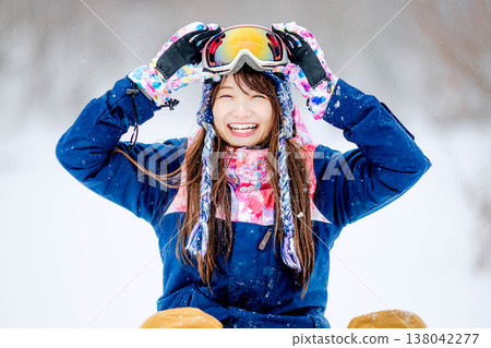 A young woman in ski wear sitting on the snow. A young woman in ski wear sitting on the snow. 138042277