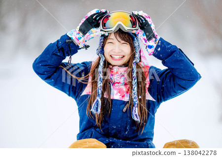 A young woman in ski wear sitting on the snow. 138042278