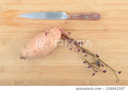 Top view of the kitchen knife and one raw sweet potato batata . Top view of the kitchen knife and one raw sweet potato batata . 138042307