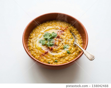 Bowl of indian dal tadka lentil soup with ghee and cilantro, served with spoon, indian food 138042488