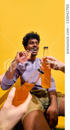 Group of young people cheering with drinks in colorful summer setting. Group of young people cheering with drinks in colorful summer setting. 138042760