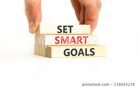 Set smart goals words symbol. Concept words Set smart goals on beautiful wooden blocks. Beautiful white background. Businessman hand. Business and set smart goals concept. Copy space. Set smart goals words symbol. Concept words Set smart goals on beautiful wooden blocks. Beautiful white background. Businessman hand. Business and set smart goals concept. Copy space. 138043238
