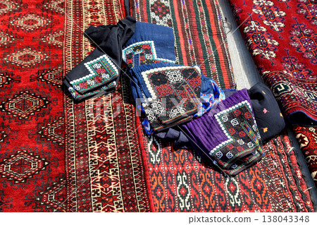 Women's trousers with Turkmen traditional embroidery. Against the background of Turkmen carpets. Turkmenistan. Ashkhabad market. Women's trousers with Turkmen traditional embroidery. Against the background of Turkmen carpets. Turkmenistan. Ashkhabad market. 138043348