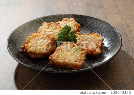 Satsuma-age (fried fish cake), a staple snack at izakayas (Japanese pubs), served on a black plate as a Japanese side dish. 138043360