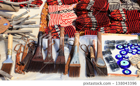 Knit slippers with traditional ornament and carpet making tools. Turkmenistan. Ashkhabad market. Knit slippers with traditional ornament and carpet making tools. Turkmenistan. Ashkhabad market. 138043396