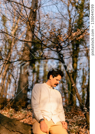 Man Sitting in Sunlit Forest Reflecting on Mental Health Man Sitting in Sunlit Forest Reflecting on Mental Health 138044599