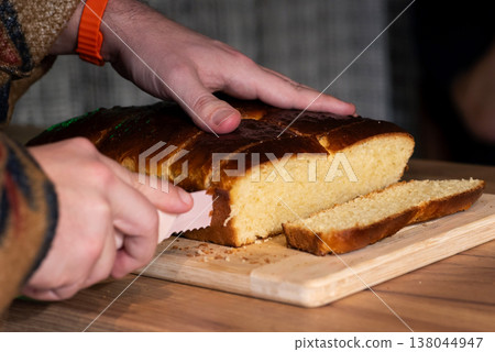 Slicing a fresh loaf of fluffy golden bread Slicing a fresh loaf of fluffy golden bread 138044947