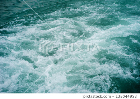 Turquoise foamy water wake texture on lake surface, dynamic motion background with splashing waves, bubbles and swirling aquatic pattern 138044958