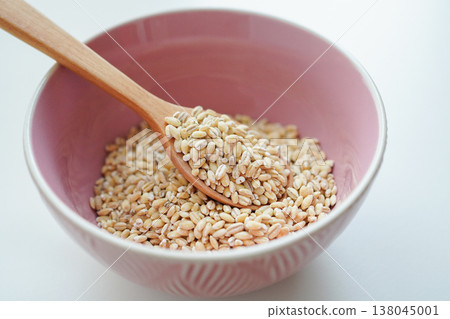 Image of healthy food: Polished pearl barley (Pearl Valley) on a white background with a wooden spoon. Image of healthy food: Polished pearl barley (Pearl Valley) on a white background with a wooden spoon. 138045001