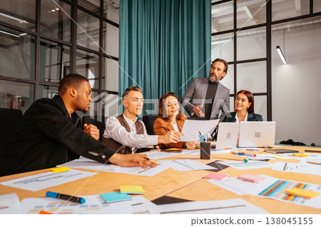 Group of people discussing ideas in a modern office setting during a business meeting in the afternoon Group of people discussing ideas in a modern office setting during a business meeting in the afternoon 138045155