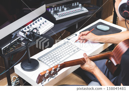 male musician writing a hit song by acoustic guitar in home studio male musician writing a hit song by acoustic guitar in home studio 138045481