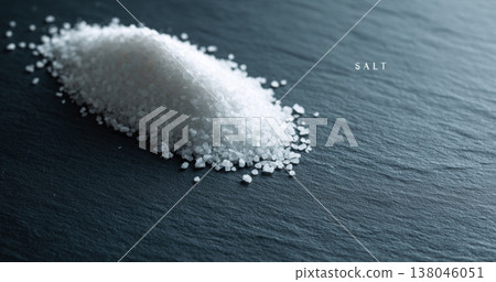 Coarse sea salt pile on dark surface 138046051