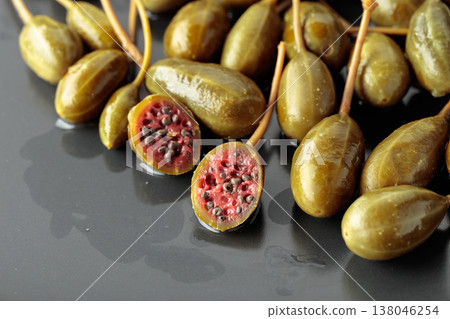 Canned capers on a black plate. 138046254