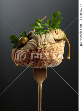 Bread with liver pate, capers, and fresh parsley on a fork. Bread with liver pate, capers, and fresh parsley on a fork. 138046263