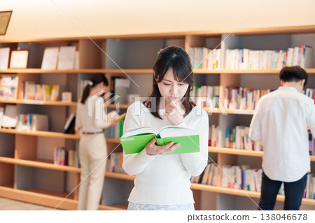 A female university student looking for specialized books. A female university student looking for specialized books. 138046678