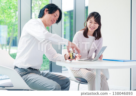 A boss holds a meeting with his female subordinate while eating rice balls. 138046893