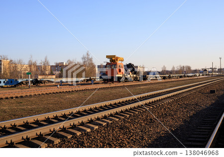 Track-laying crane in the background of a railroad track. Specialized piece of railway equipment Track-laying crane in the background of a railroad track. Specialized piece of railway equipment 138046968