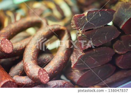 Assorted cured sausages and sliced cured meat displayed at a traditional deli counter Assorted cured sausages and sliced cured meat displayed at a traditional deli counter 138047837