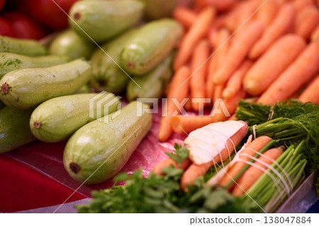 Fresh carrots and zucchini on display at a farmers market stall with organic produce bundles Fresh carrots and zucchini on display at a farmers market stall with organic produce bundles 138047884