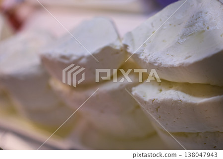 Stack of fresh goat cheese rounds showing soft white creamy texture on display at a market Stack of fresh goat cheese rounds showing soft white creamy texture on display at a market 138047943