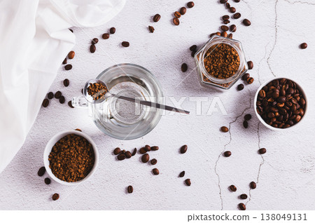 A cup of water, instant coffee granules and coffee beans on the table top view A cup of water, instant coffee granules and coffee beans on the table top view 138049131