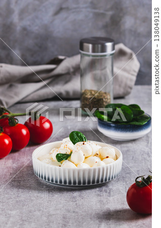 Mozzarella cheese in small balls in a bowl on the table vertical view Mozzarella cheese in small balls in a bowl on the table vertical view 138049138