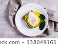 Close up of rye bread with guacamole and poached egg on a plate on the table top view 138049161