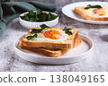 An egg baked in pieces of bread on a plate on the table 138049165