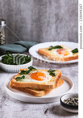 An egg baked in pieces of bread on a plate on the table vertical view 138049167