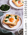 Baked toast with egg and parsley on a plate on the table vertical view 138049168