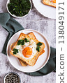 Baked toast with egg and parsley on a plate on the table top and vertical view 138049171